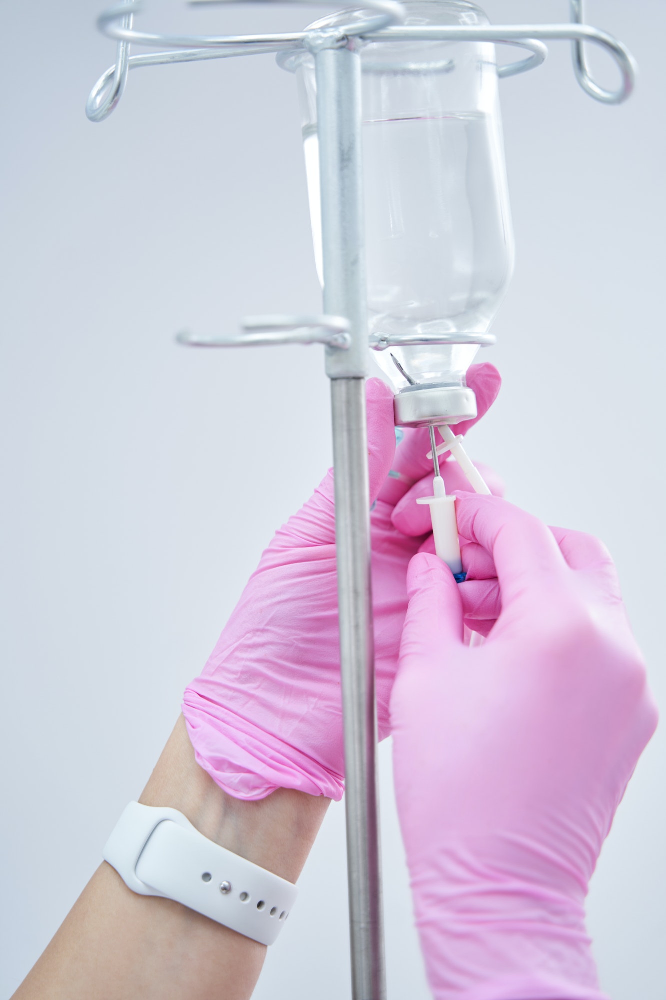 Close up photo of cosmetologist hands fixing IV infusion for client